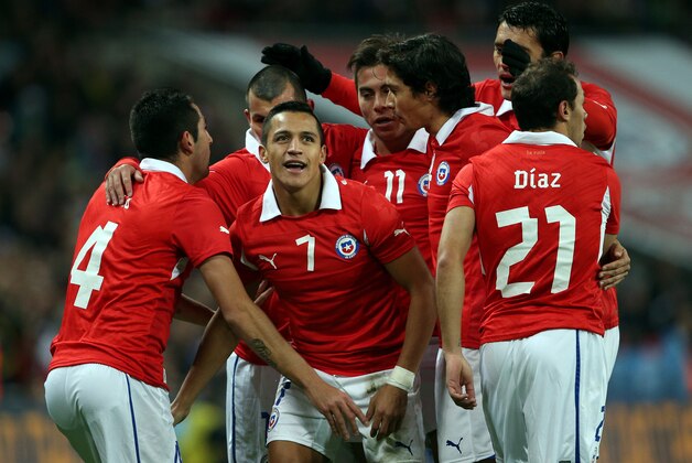 LONDON, ENGLAND - NOVEMBER 15:  Alexis Sanchez of Chile celebrates with his teammates after scoring the opening goal during the international friendly match between England and Chile at Wembley Stadium on November 15, 2013 in London, England.  (Photo by Clive Brunskill/Getty Images)