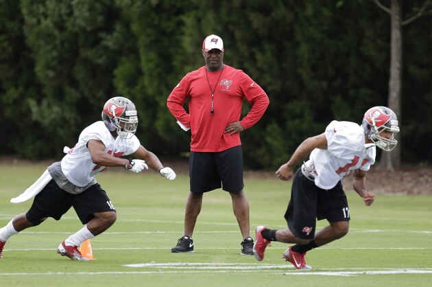 Tampa Bay Buccaneers head coach Lovie Smith, center, watches wide receivers Sky Dawson, left, and Eric Page, right, during a Buccaneers minicamp voluntary NFL football practice Tuesday, April 22, 2014, in Tampa, Fla. (AP Photo/Chris O'Meara)