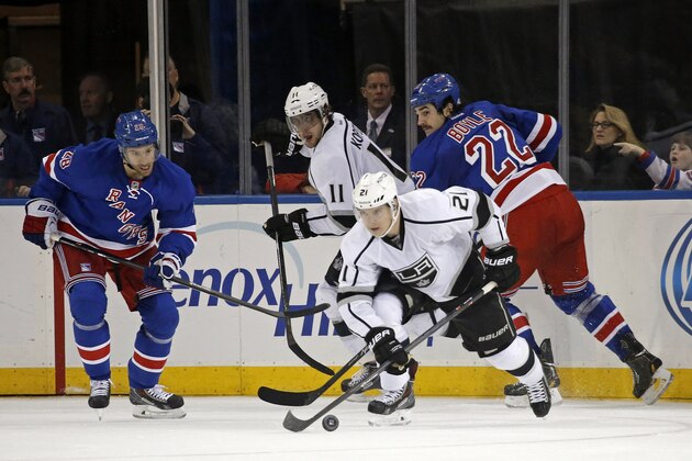 Los Angeles Kings right wing Matt Frattin (21) looks for a shot with New York Rangers center Dominic Moore (28) and New York Rangers center Brian Boyle (22) defending in the second period of their NHL hockey game at Madison Square Garden in New York, Sunday, Nov. 17, 2013.  (AP Photo/Kathy Willens)