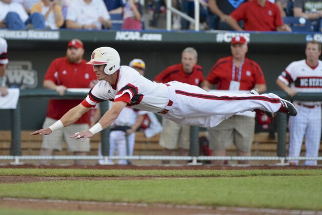 North Carolina State's Jake Armstrong leaps towards home plate before being tagged out by UCLA pitcher Nick Vander Tuig, following a single by Trea Turner in the third inning of an NCAA College World Series game in Omaha, Neb., Tuesday, June 18, 2013. (AP Photo/Ted Kirk)