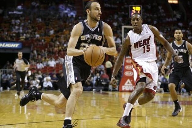 San Antonio Spurs' Manu Ginobili, left, drives to the basket past Miami Heat's Mario Chalmers (15) during the first half of an NBA preseason basketball game, Saturday, Oct. 19, 2013, in Miami. (AP Photo/Lynne Sladky)