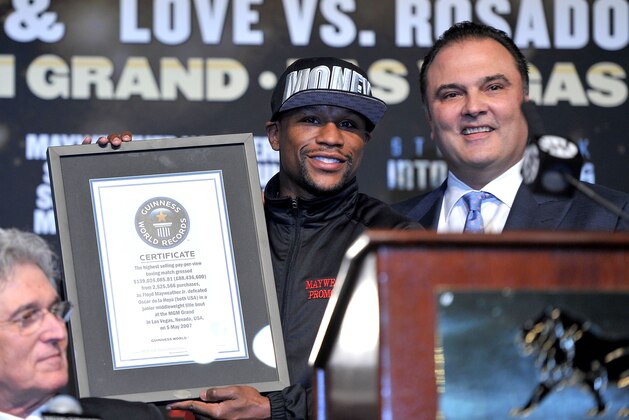 LAS VEGAS, NV - MAY 01:  Boxer Floyd Mayweather Jr. (L) receives a Guiness World Record from CEO of Golden Boy Promotions Richard Schaefer during the final news conference for his bout against boxer Robert Guerrero at the MGM Grand Hotel/Casino on May 1, 2013 in Las Vegas, Nevada. Mayweather will defend his WBC welterweight title against Guerrero. The Guiness World Record Certificate read 'The highest selling pay-per view boxing match grossed $139,024,085.81 from 2,525,566 purchases, as Floyd Mayweather Jr. defeated Oscar De La Hoya (both USA) in a junior middleweight  title bout at the MGM Grand in Las Vegas, Nevada, USA, on May 5, 2007.' (Photo by Jeff Bottari/Getty Images)