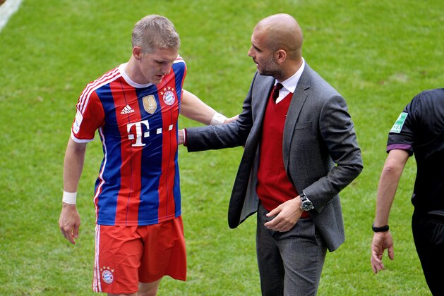 Bayern head coach Pep Guardiola, right, speaks to his player Bastian Schweinsteiger  during the  soccer match between FC Bayern Munich and VfB Stuttgart in the Allianz Arena in Munich, Germany, on Saturday, May 10. 2014. (AP Photo/Kerstin Joensson)