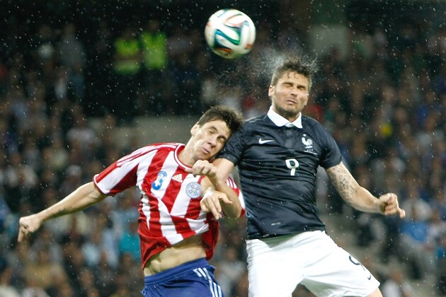 French soccer team forward Olivier Giroud, right, Paraguayan soccer team defender Danilo Fabian Ortiz Soto, challenges for the ball with  during the friendly soccer match between France and Paraguay at the Allianz Riviera Stadium, in Nice, southeastern France, Sunday, June 1, 2014. France is preparing for the upcoming soccer World Cup in Brazil starting on 12 June. (AP Photo/Claude Paris)