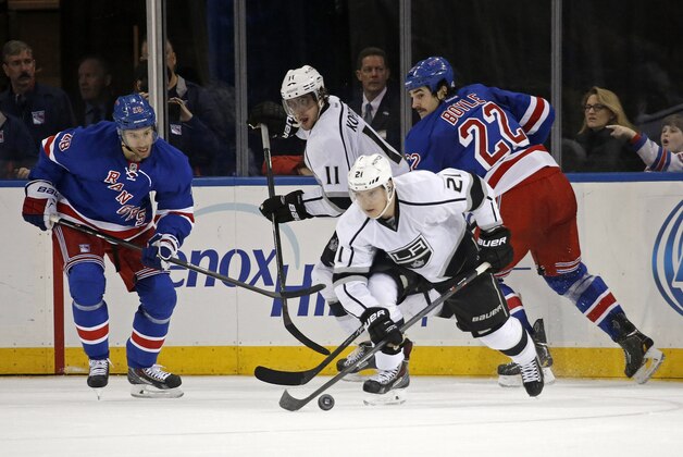 Los Angeles Kings right wing Matt Frattin (21) looks for a shot with New York Rangers center Dominic Moore (28) and New York Rangers center Brian Boyle (22) defending in the second period of their NHL hockey game at Madison Square Garden in New York, Sunday, Nov. 17, 2013.  (AP Photo/Kathy Willens)