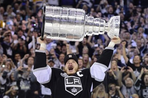 Los Angeles Kings right wing Dustin Brown (23) holds up the Stanley Cup after the Kings beat the New Jersey Devils 6-1 during Game 6 of the NHL hockey Stanley Cup finals, Monday, June 11, 2012, in Los Angeles. (AP Photo/Mark J. Terrill)