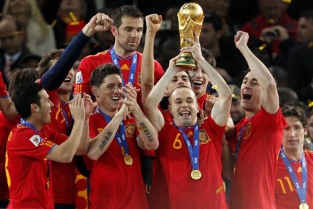 Spain's Andres Iniesta, second from right, holds up the World Cup trophy as team members celebrate at the end of the World Cup final soccer match between the Netherlands and Spain at Soccer City in Johannesburg, South Africa, Sunday, July 11, 2010. Spain won 1-0. (AP Photo/Bernat Armangue)