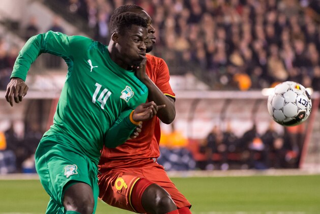 Belgium's Christian Benteke, back, challenges Ivory Coast's Serge Aurier during a friendly soccer match at the King Baudouin stadium in Brussels on Wednesday March 5, 2014. (AP Photo/Geert Vanden Wijngaert)
