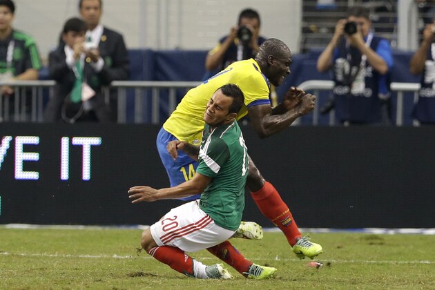 Mexico's Luis Montes collides with Ecuador's Segundo Castillo, rear, as the two were competing for the ball during the first half of a friendly soccer match, Saturday, May 31, 2014, in Arlington, Texas. Montes, who took the brunt of the collision was stretchered off the pitch after fracturing his right tibia and fibula. (AP Photo/Tony Gutierrez)