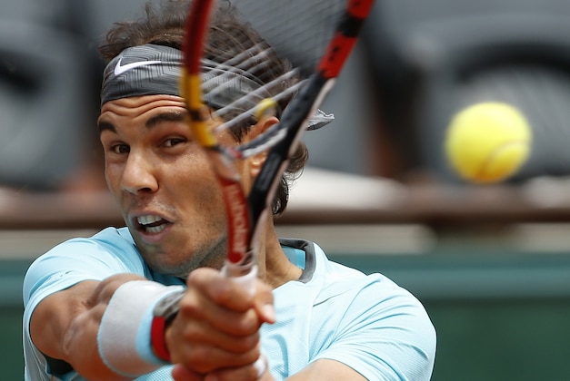 Spain's Rafael Nadal returns the ball to Serbia's Dusan Lajovic during their fourth round match of  the French Open tennis tournament at the Roland Garros stadium, in Paris, France, Monday, June 2, 2014. (AP Photo/Darko Vojinovic)