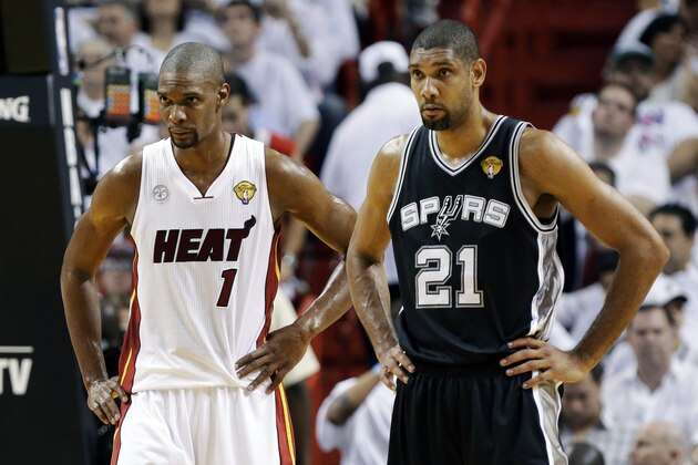 Miami Heat center Chris Bosh (1) and San Antonio Spurs forward Tim Duncan (21) stand on the court during the first half of Game 6  in their NBA Finals basketball series, Tuesday, June 18, 2013 in Miami. (AP Photo/Lynne Sladky)