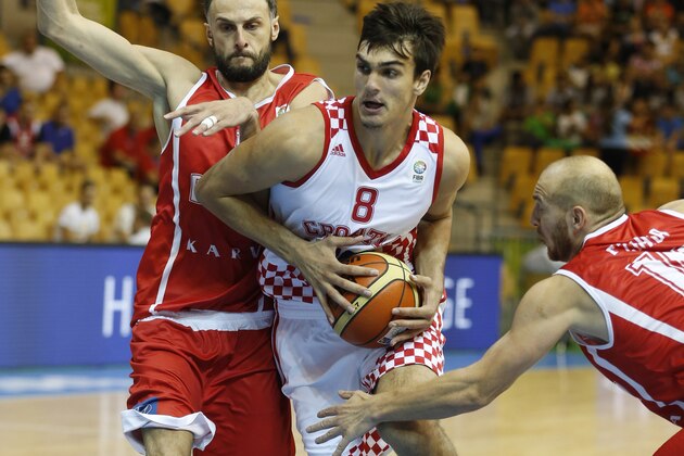Croatia's Dario Saric, center, drives a ball past Georgia's Besik Lezhava, right, and Georgia's Viktor Sanikidze, left, during their EuroBasket European Basketball Championship Group C match in Celje, Slovenia, Thursday, Sept. 5, 2013. (AP Photo/Petr David Josek)