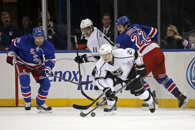 Los Angeles Kings right wing Matt Frattin (21) looks for a shot with New York Rangers center Dominic Moore (28) and New York Rangers center Brian Boyle (22) defending in the second period of their NHL hockey game at Madison Square Garden in New York, Sunday, Nov. 17, 2013.  (AP Photo/Kathy Willens)