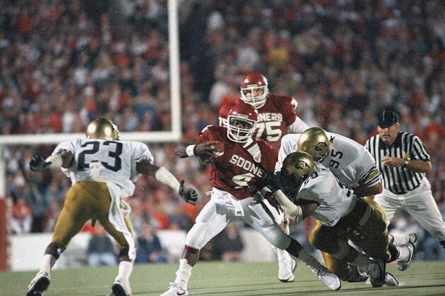 Oklahoma quarterback Jamelle Holieway, 4, is tackled by a host of Colorado defenders during first quarter action in Norman, Oklahoma, Oct. 24, 1987. The No.1 ranked Sooners led the Buffaloes 10-6 at the half. (AP Photo/David Longstreath)