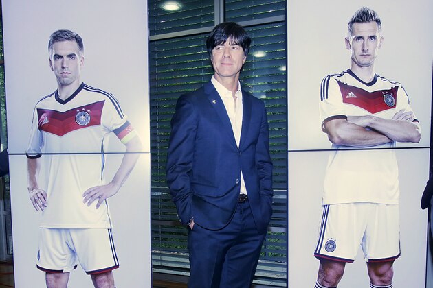 Coach of the German national soccer team Joachim Loew stands next to pictures of players Philipp Lahm, left, and Miroslav Klose after a press conference where he presented his preliminary team for the upcoming World Cup in Brazil in Frankfurt, Germany, Thursday, May 8, 2014. (AP Photo/Michael Probst)