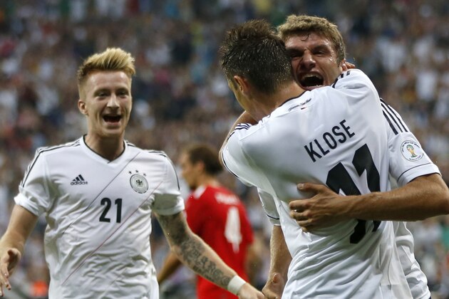 Germany's Miroslav Klose hugs team mate Thomas Mueller after scoring his side's opening goal  during their FIFA World Cup 2014 qualification group C soccer match between Germany and Austria in Munich, southern Germany, Friday, Sept. 6, 2013. Left team mate Marco Reus. (AP Photo/Matthias Schrader)