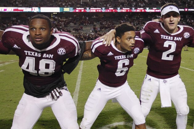 ILE -  In this Sept. 21, 2013, file photo, Texas A&M freshman linebacker Darian Claiborne (48), quarterback Johnny Manziel (2) and defensive back Noel Ellis (6) sing the Aggie War Hymm during an NCAA college football game in College Station, Texas. UCLA and Texas A&M each have played 17 true freshmen this season, tied for most among the programs at the highest level of the game. An Associated Press analysis of depth charts and game reports for the 72 BCS-conference teams and Notre Dame this week showed that 359 freshmen were listed as first- or second-stringers, not including special teams. That represented almost 12 percent of the total of 3,212 players. (AP Photo/Bob Levey)