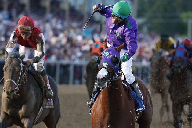 Jockey Victor Espinoza, center, aboard California Chrome, celebrates after winning the 139th Preakness Stakes horse race at Pimlico Race Course, Saturday, May 17, 2014, in Baltimore. Ride On Curlin, left, ridden by Joel Rosario, finished second. (AP Photo/Matt Slocum)