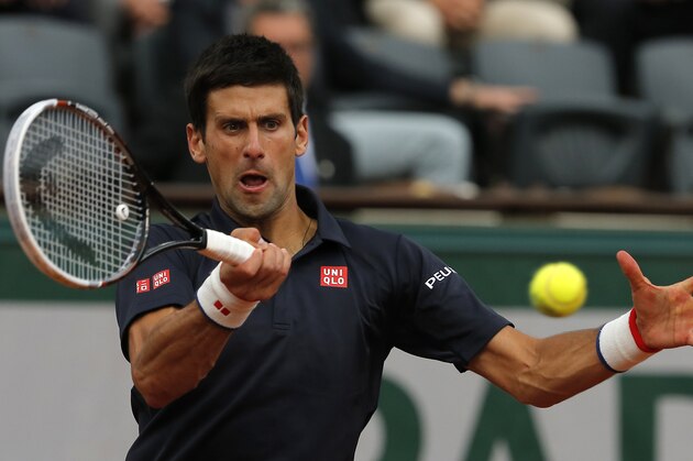 Serbia's Novak Djokovic returns the ball to Canada's Milos Raonic during their quarterfinal match of  the French Open tennis tournament at the Roland Garros stadium, in Paris, France, Tuesday, June 3, 2014. Djokovic won 7-5, 7-6, 6-4. (AP Photo/Michel Spingler)