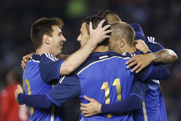 Argentina's Maximiliano Rodriguez, center, celebrates his goal against Trinidad and Tobago with teammate Lionel Messi, left, during an international friendly soccer match in Buenos Aires, Argentina, Wednesday, June 4, 2014. (AP Photo/Victor R. Caivano)