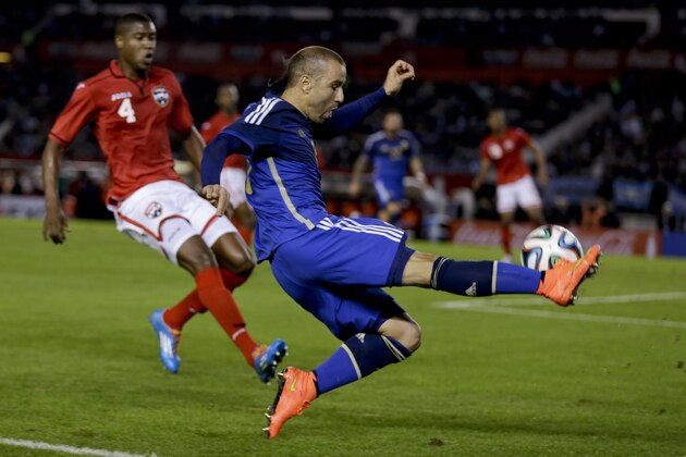 Argentina's Rodrigo Palacio, right, vies for the ball with Trinidad and Tobago's Sheldon Bateau during their international friendly soccer match in Buenos Aires, Argentina, Wednesday, June 4, 2014. (AP Photo/Natacha Pisarenko)