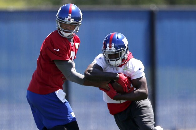 New York Giants quarterback Josh Freeman, left, hands off to running back David Wilson during an NFL football organized team activity, Thursday, May 29, 2014, in East Rutherford, N.J. (AP Photo/Julio Cortez)