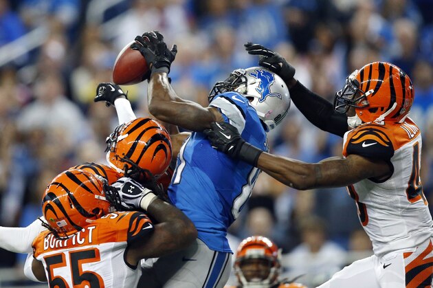 Detroit Lions wide receiver Calvin Johnson, second from right, catches a 50-yard touchdown reception over Cincinnati Bengals outside linebacker Vontaze Burfict, left, free safety Reggie Nelson, second from left, and strong safety George Iloka in the fourth quarter of an NFL football game Sunday, Oct. 20, 2013, in Detroit. (AP Photo/Rick Osentoski)