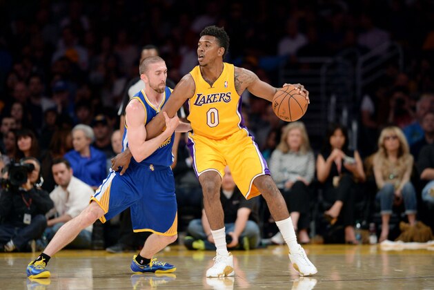 LOS ANGELES, CA - APRIL 11: Nick Young #0 of the Los Angeles Lakers handles the ball against Steve Blake #25 of the Golden State Warriors at Staples Center on April 11, 2014 in Los Angeles, California. NOTE TO USER: User expressly acknowledges and agrees that, by downloading and/or using this Photograph, user is consenting to the terms and conditions of the Getty Images License Agreement. Mandatory Copyright Notice: Copyright 2014 NBAE (Photo by Noah Graham/NBAE via Getty Images)