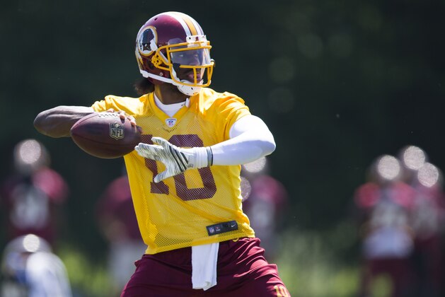 Washington Redskins quarterback Robert Griffin III throws a pass during an NFL football practice at Redskins Park, on Wednesday, June 4, 2014, in Ashburn, Va. (AP Photo/ Evan Vucci)
