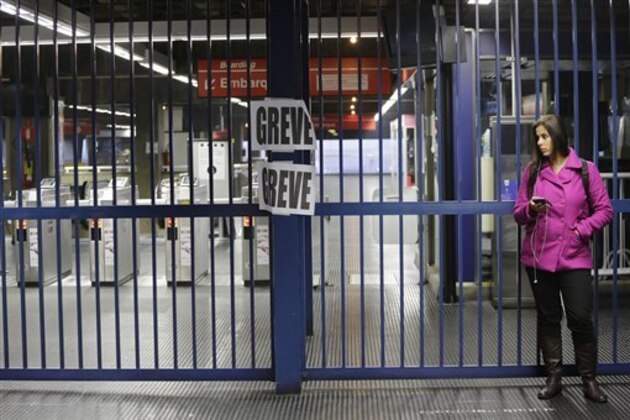A commuter stands at the closed Belem metro station where a sign hangs that reads in Portuguese