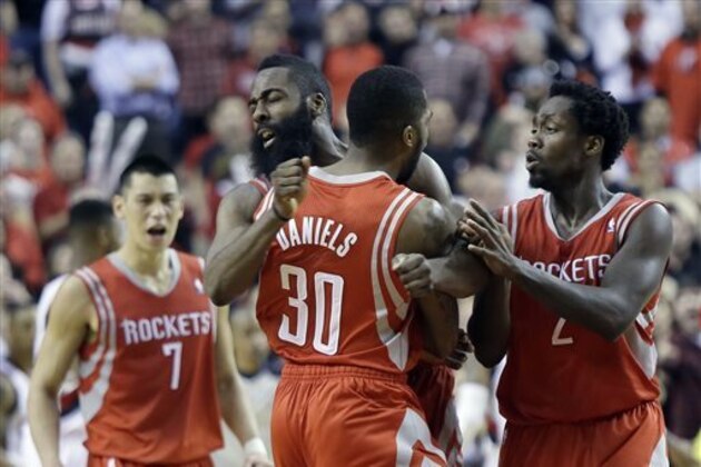 CORRECTS PERIOD TO OVERTIME - Houston Rockets guard Troy Daniel, middle, celebrates with teammates James Harden, left, and Patrick Beverley after sinking a three point shot in overtime to take the lead during Game 3 of an NBA basketball first-round playoff series against the Portland Trail Blazers in Portland, Ore., Friday, April 25, 2014.  The Rockets won 121-116. (AP Photo/Don Ryan)