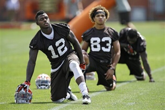 El receptor de los Browns de Cleveland, Josh Gordon (12), hace estiramientos en las instalaciones del equipo en Berea, Ohio el martes 3 de junio de 2014. Gordon, está esperando una posible segunda sanción por parte de la NFL por abuso de drogas y fue citado por manejar con exceso de velocidad. (AP Photo/Mark Duncan)