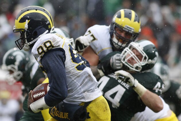 Michigan quarterback Devin Gardner (98) runs on a keeper in front of Michigan State's Marcus Rush (44) and Taylor Lewan (77) during the second quarter of an NCAA college football game, Saturday, Nov. 2, 2013, in East Lansing, Mich. (AP Photo/Al Goldis)