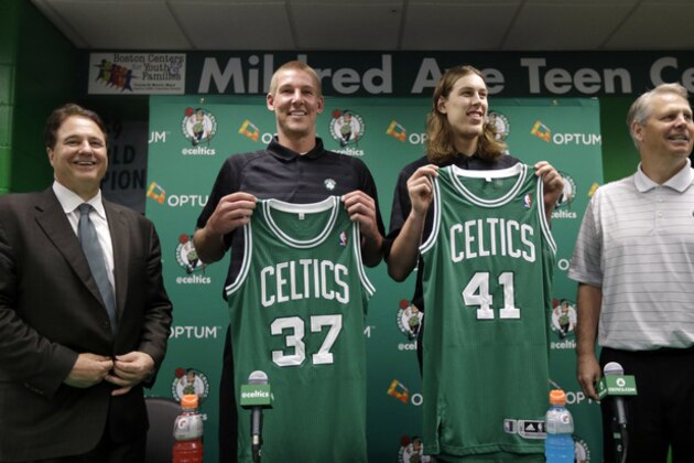 Boston Celtics 2013 NBA basketball draft picks Colton Iverson, center left, and Kelly Olynyk, center right, display their jerseys as Celtics co-owner Stephen Pagliuca, left, and Celtics general manager of basketball operations Danny Ainge, right, look on during a news conference held to introduce the players, in Boston, Monday, July 1, 2013. (AP Photo/Steven Senne)