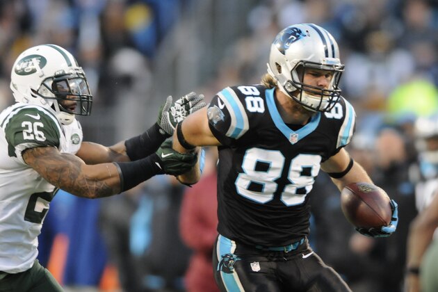 Carolina Panthers' Greg Olsen (88) is caught by New York Jets' Dawan Landry (26) during the first half of an NFL football game in Charlotte, N.C., Sunday, Dec. 15, 2013. (AP Photo/Mike McCarn)