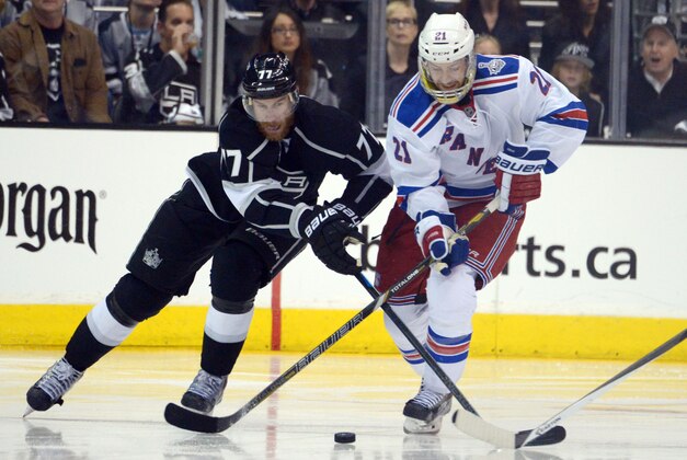 Jun 4, 2014; Los Angeles, CA, USA;  Los Angeles Kings center Jeff Carter (77) and New York Rangers center Derek Stepan (21) battle for the puck during overtime in game one of the 2014 Stanley Cup Final at Staples Center. Mandatory Credit: Kirby Lee-USA TODAY Sports