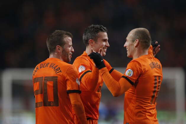 Three offense players Rafael van der Vaart, left, Robin van Persie, center, and Arjen Robben, right, of The Netherlands celebrate after van Persie scored 2-0 during the Group D world cup qualifying soccer match Netherlands against Estonia at ArenA stadium in Amsterdam, Netherlands, Friday March 22, 2013. (AP Photo/Peter Dejong)