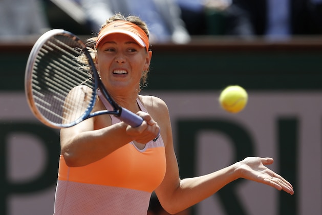 Russia's Maria Sharapova returns the ball to Canada's Eugenie Bouchard during their semifinal match of  the French Open tennis tournament at the Roland Garros stadium, in Paris, France, Thursday, June 5, 2014. (AP Photo/Darko Vojinovic)