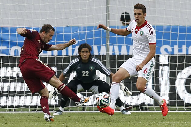 Russia's Alexander Kerzhakov, left, shoots as Morocco's Zouhair Feddal, right, tries to block during a friendly soccer match in Moscow, Russia, Friday, June 6, 2014. Russia won 2-0. This is the last friendly match before the Russian team leaves for Brazil to compete in the World Cup. (AP Photo/\Name\)