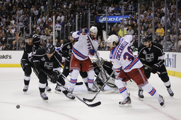 Los Angeles Kings' Jeff Carter (77), Marian Gaborik (12), Slava Voynov (26), New York Rangers' Benoit Pouliot (67) and Mats Zuccarello (36) look at the puck during the third period of Game 1 in the NHL Stanley Cup Final hockey series on Wednesday, June 4, 2014, in Los Angeles. (AP Photo/Jae C. Hong)