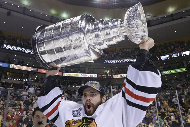 FILE - In this June 24, 2013 file photo, Chicago Blackhawks goalie Corey Crawford hoists the Stanley Cup after the Blackhawks beat the Boston Bruins 3-2 in Game 6 of the NHL hockey Stanley Cup Finals, in Boston. The cup will make a special visit to Saint Mary's University in Winona, Minn. on Friday. (AP Photo/Elise Amendola, File)