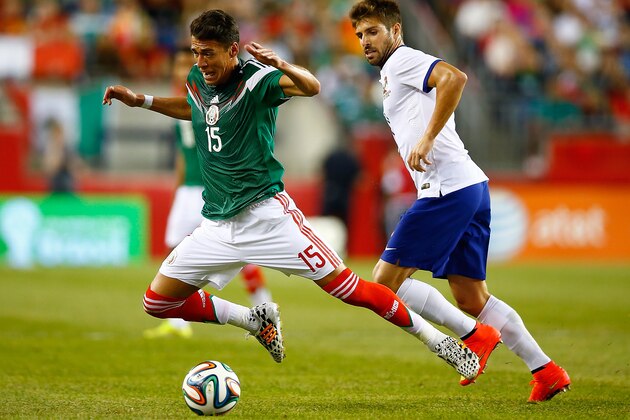 FOXBORO, MA - JUNE 06: Hector Moreno #15 of Mexico is fouled by Miguel Veloso #4 of Portugal in the first half during the international friendly match at Gillette Stadium on June 6, 2014 in Foxboro, Massachusetts.  (Photo by Jared Wickerham/Getty Images)