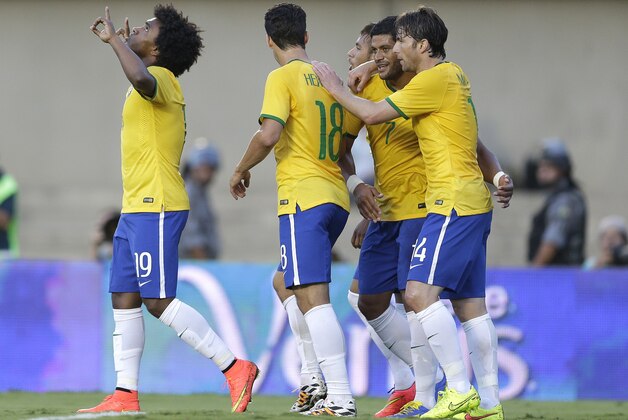 Brazil's Willian, left,  celebrates with teammates after scoring against Panama's during a friendly soccer match at the Serra Dourada stadium in Goiania, Brazil, Tuesday, June 3, 2014.  Brazil is preparing for the World Cup soccer tournament that starts on 12 June. (AP Photo/Andre Penner)