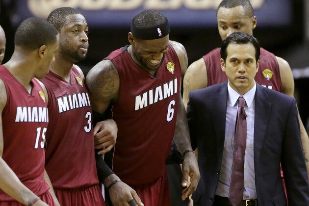 Miami Heat forward LeBron James (6) is helped from the court by guard Mario Chalmers (15), guard Dwyane Wade (3), Erik Spoelstra, front, right, and Rashard Lewis, right rear, during the second half in Game 1 of the NBA basketball finals on Thursday, June 5, 2014 in San Antonio. (AP Photo/Eric Gay)