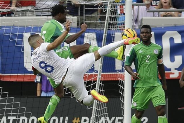 United States's Clint Dempsey (8) takes a shot on goal as he is defended by Nigeria's Efe Ambrose, center, as Joseph Yobo (2) looks on during the first half of an international friendly soccer match in Jacksonville, Fla., Saturday, June 7, 2014. (AP Photo/John Raoux)
