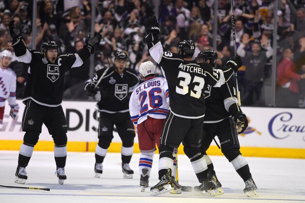 Los Angeles Kings' Dustin Brown, left, celebrates his game-winning goal with teammates as New York Rangers right wing Martin St. Louis, center, looks on in the second overtime period in Game 2 of the NHL hockey Stanley Cup Finals, Saturday, June 7, 2014, in Los Angeles. The Kings won 5-4.  (AP Photo/Mark J. Terrill)