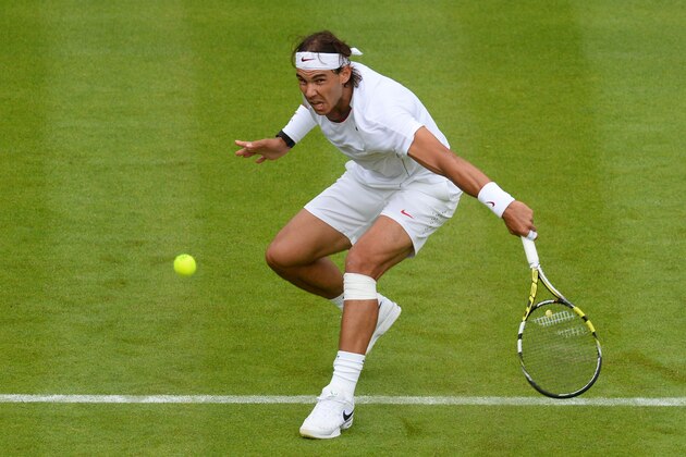LONDON, ENGLAND - JUNE 24:  Rafael Nadal of Spain plays a backhand during his Gentlemen's Singles first round match against Steve Darcis of Belgium on day one of the Wimbledon Lawn Tennis Championships at the All England Lawn Tennis and Croquet Club on June 24, 2013 in London, England.  (Photo by Mike Hewitt/Getty Images)