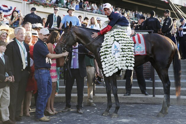 Jockey Joel Rosario poses for photos atop Tonalist after winning the 146th running of the Belmont Stakes horse race, Saturday, June 7, 2014, in Elmont, N.Y. (AP Photo/Seth Wenig)