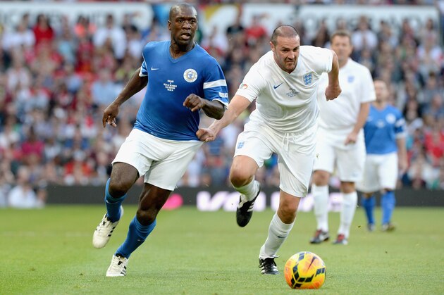 MANCHESTER, ENGLAND - JUNE 08:  Clarence Seedorf of the Rest of the World and Paddy McGuinness of England battle for the ball during Soccer Aid 2014 at Old Trafford on June 8, 2014 in Manchester, England.  (Photo by Dave J Hogan/Getty Images)