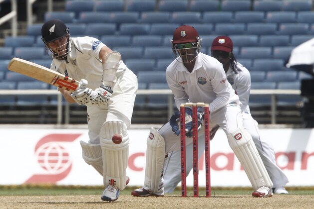 New Zealand's batsman Kane Williamson, left, plays a shot as West Indies wicket keeper Denesh Ramdin center, and Chris Gayle, right back, looks on during the opening day of their first cricket Test match in Kingston, Jamaica, Sunday, June 8, 2014. (AP Photo/Arnulfo Franco)